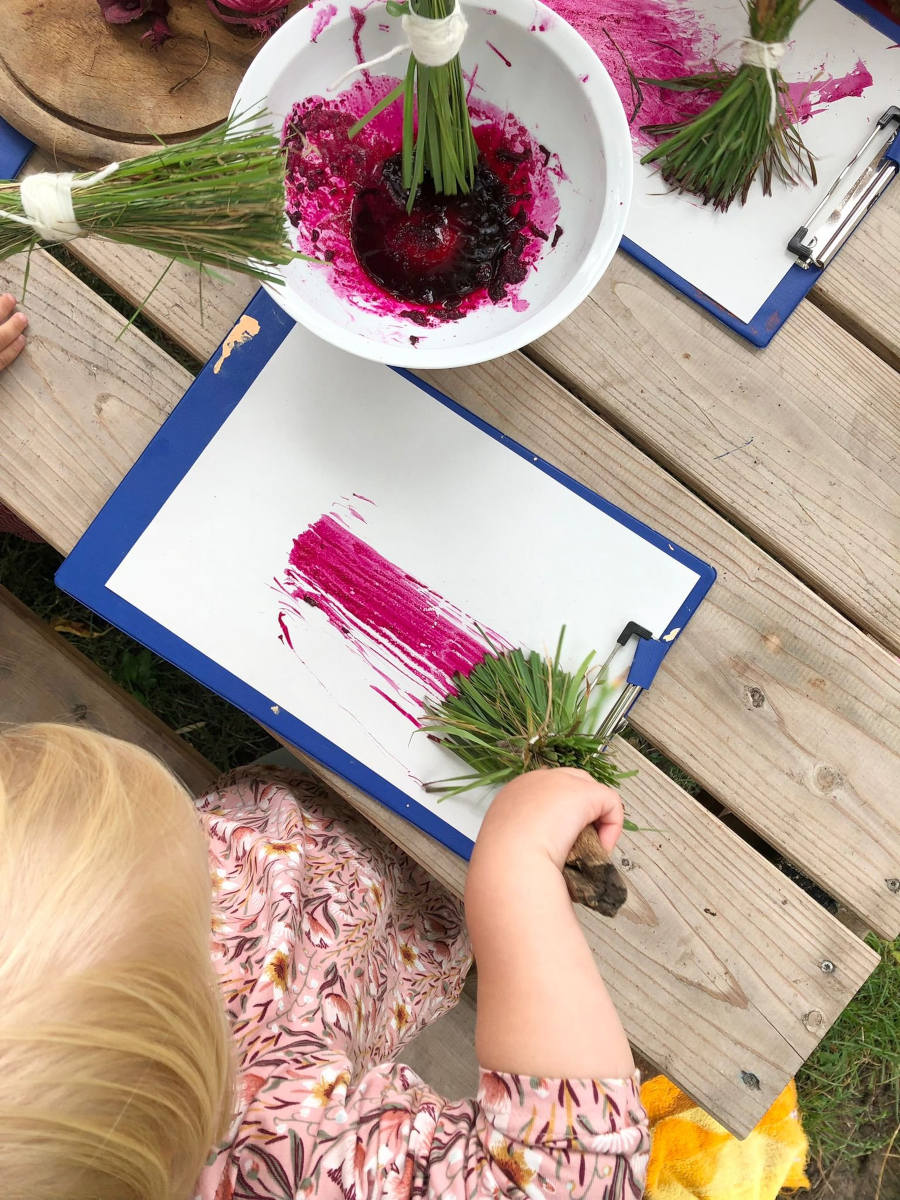 Kinder malen mit Gras in der Natur